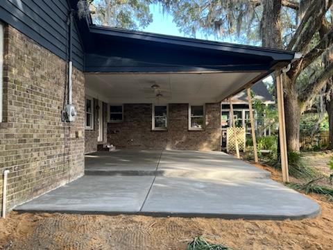 Covered patio concrete project beside a brick home