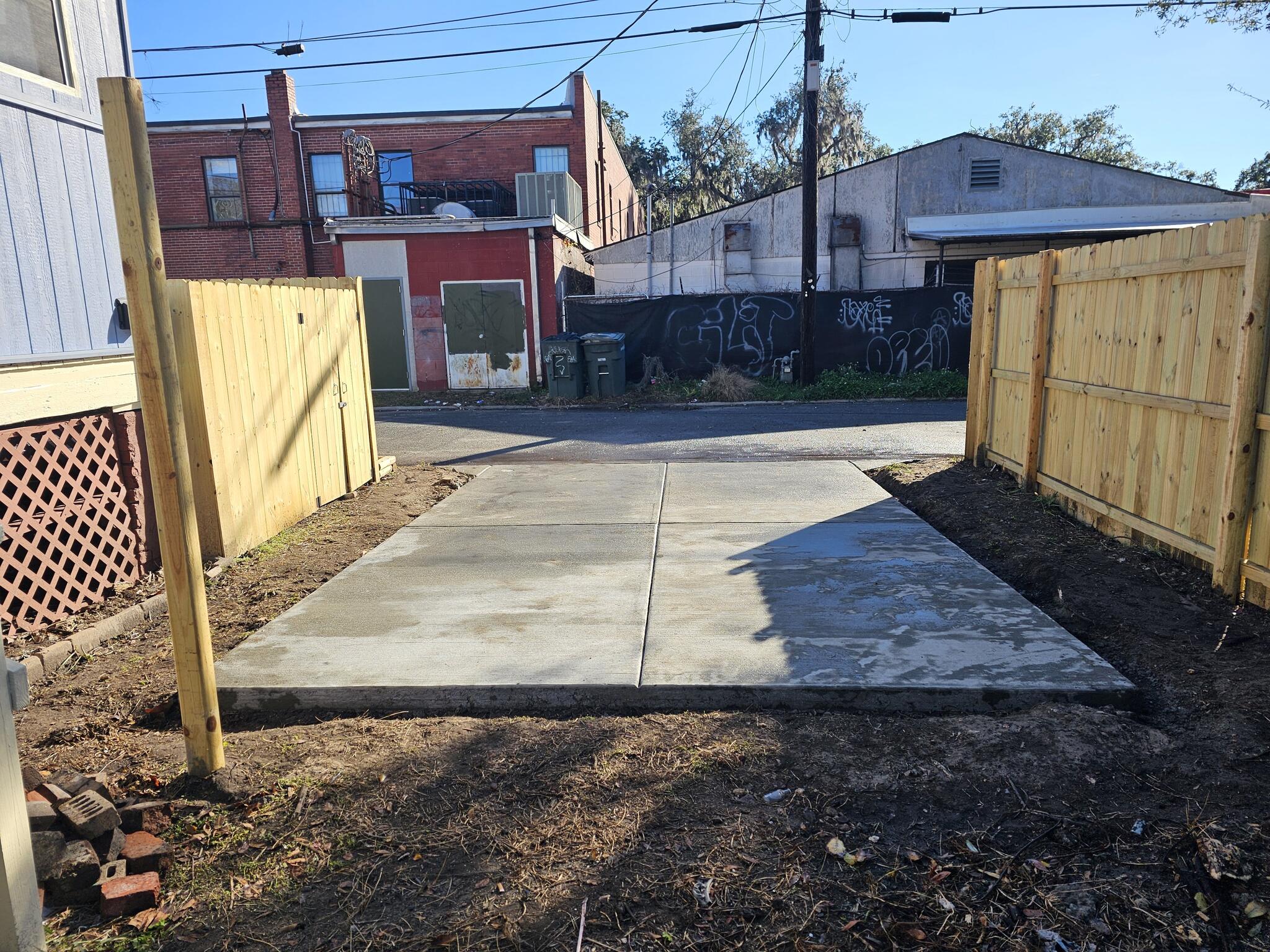Symmetrical finished driveway slab between fences